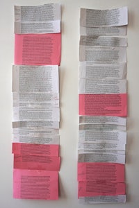 a stack of pink paper on a wall