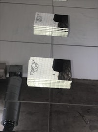 a group of books on a table in front of a mirror